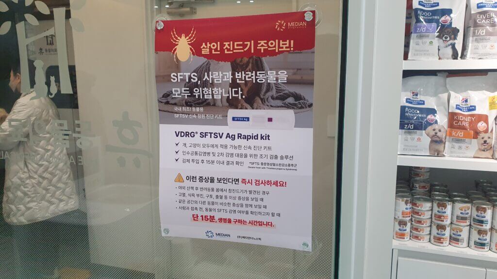 동물병원 대기실에서 확인한 살인 진드기(SFTS) 감염 위험 안내 포스터. 반려견 산책 후 진드기 확인과 예방 관리의 중요성을 강조하고 있습니다.